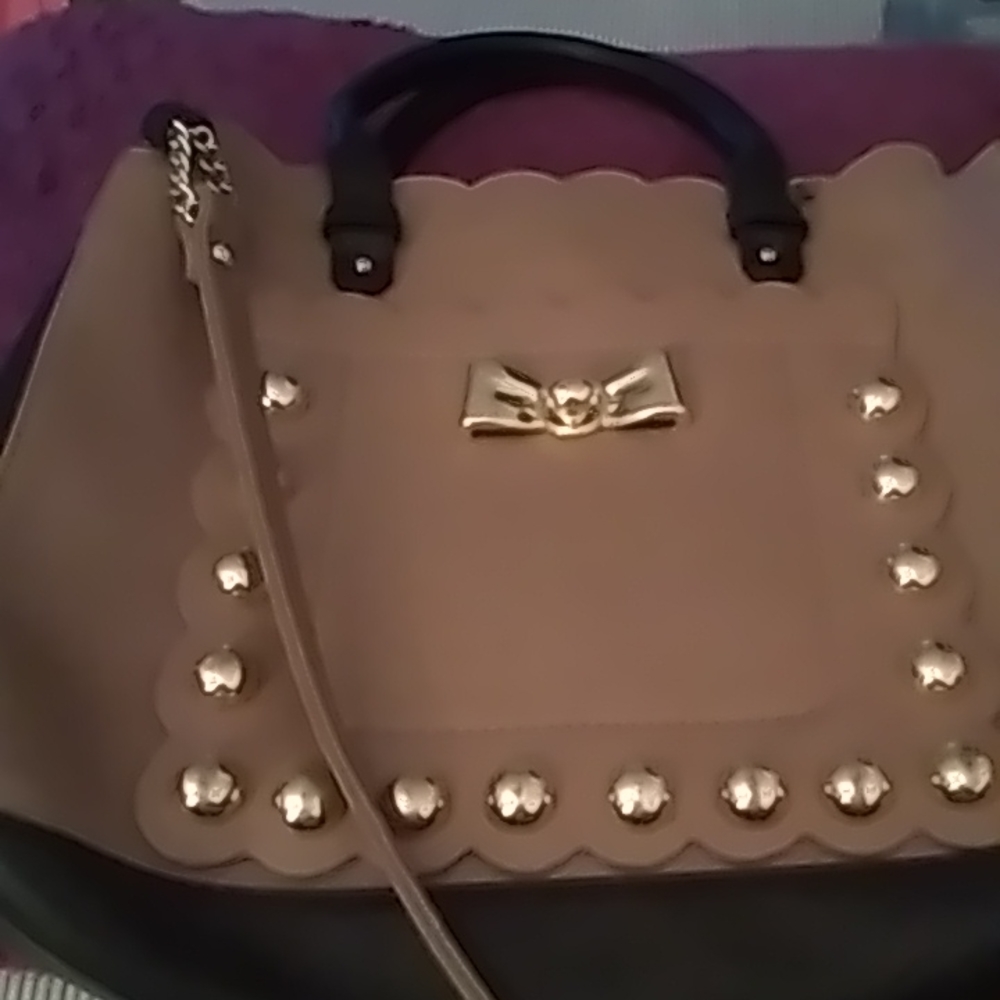 Betsy Johnson beige purse with long shoulder strap.